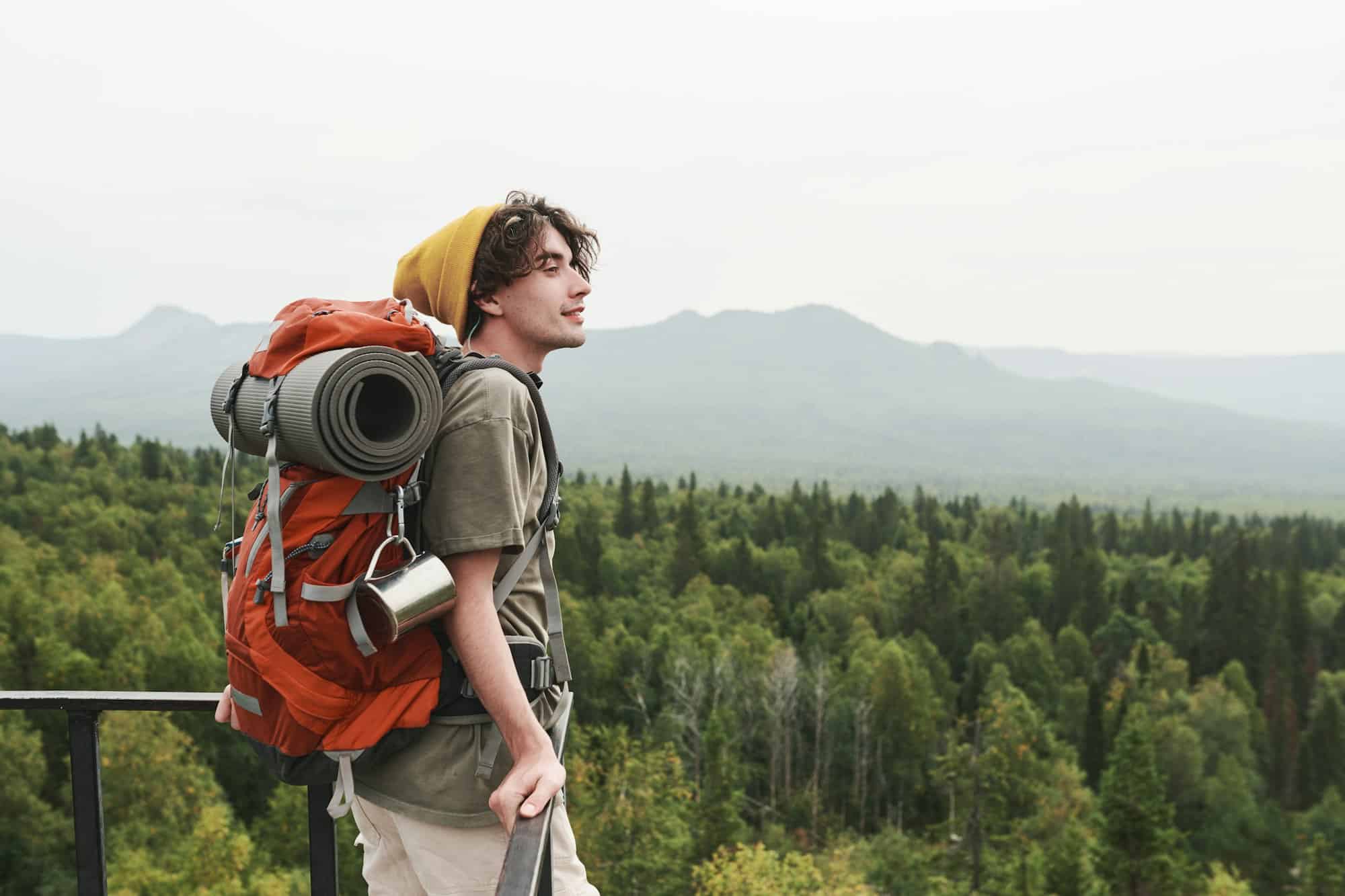 Young hiker contemplating forest