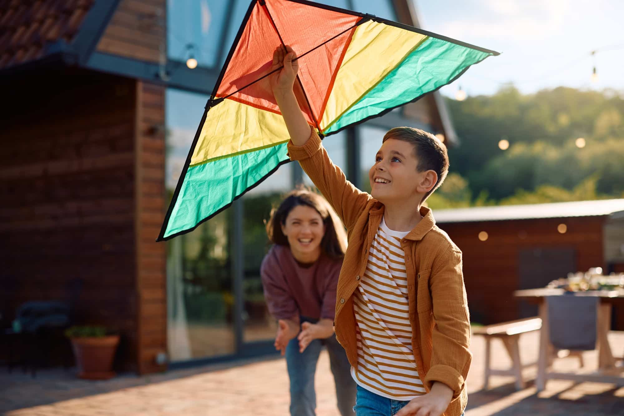 Happy kid having fun while flying a kite outdoors.